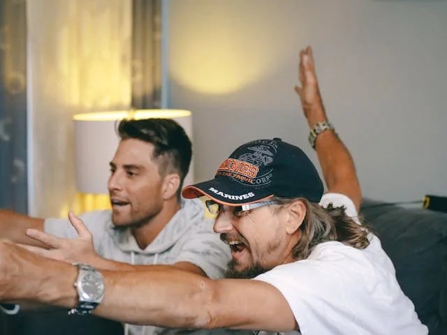 2 men watching sports on TV